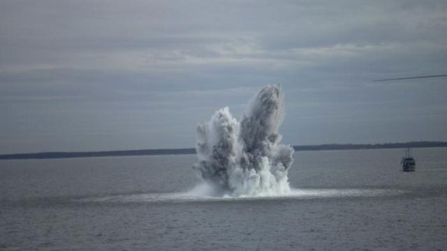 An explosion underwater produces a large disturbance of water at the surface. 